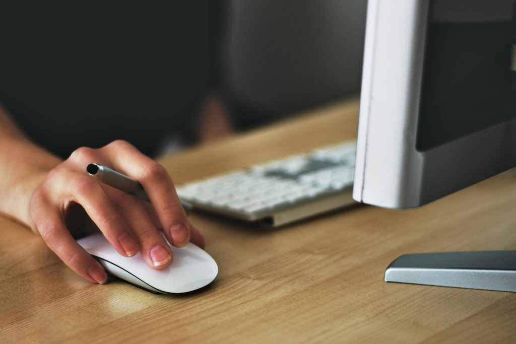 Person using computer mouse at desk