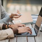 two people using a laptop